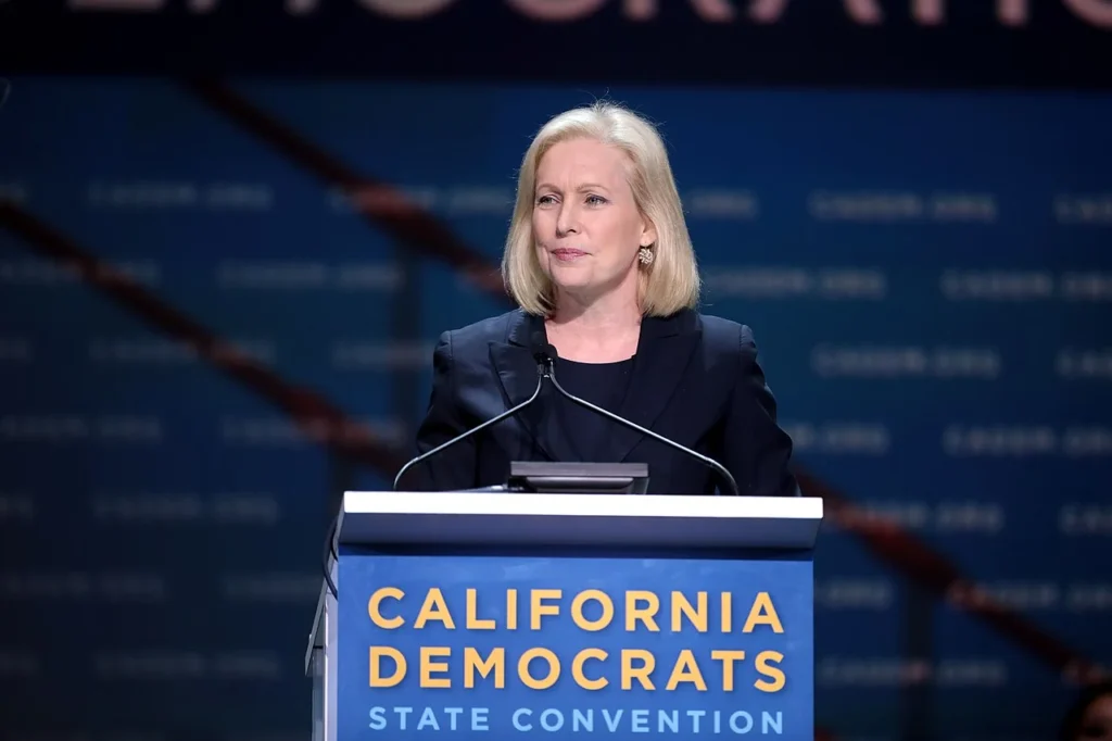Kirsten Gillibrand speaking at a Democratic State Convention podium.