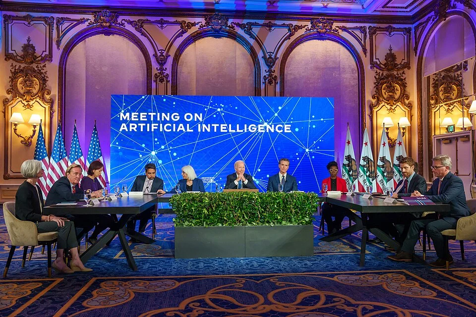 Sal Khan seated at a roundtable meeting on Artificial Intelligence with U.S. President Joe Biden and California Governor Gavin Newsom.