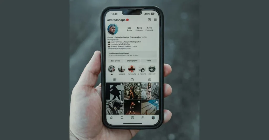 Hand holding a phone displaying an optimized Instagram creator profile with professional dashboard