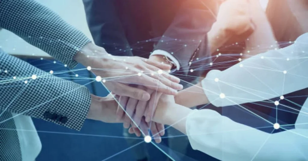 Business team joining hands with digital network overlay representing collaboration