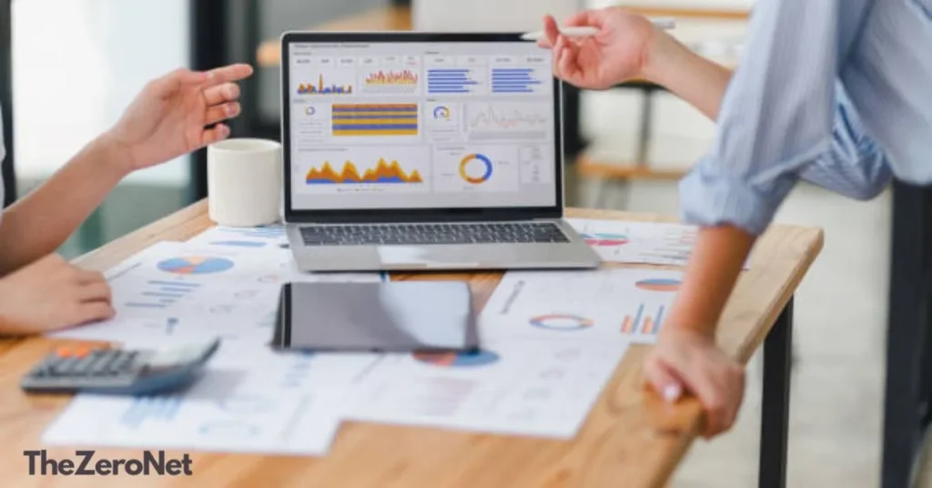 Two professionals reviewing procurement spend analytics dashboard on laptop in office meeting
